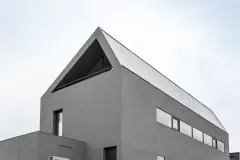 Haus mit großflächiger grauer Putzfassade