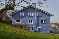 Am Hang gelegenes, hellblaues Einfamilienhaus