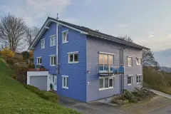 Ansicht eines Hauses mit hellblauer Holzfassade