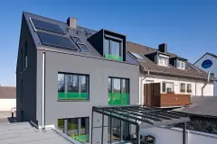 Haus mit dunkelgrauer verputzter Fassade