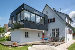 Kubischer Anbau mit schwarzer Glasfassade
