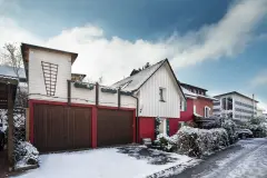 Rotes Haus mit weißen und grünen Holzelementen