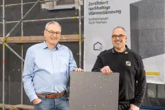 Der Sto-Verkaufsberater Herr Michael Bringmann (links) und der Geschäftsführer der JWS GmbH Herrn Jan Wucherpfennig (rechts) präsentieren die neue Sto-Dämmplatte Top32 Biomass vor einem Sanierungsobjekt in Göttingen.